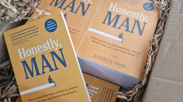Copies of the book Honestly, Man by Andrew Pain in a delivery box packed with shredded paper.