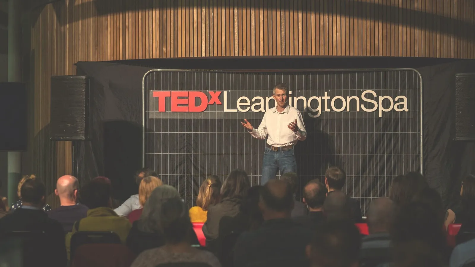 Andrew Pain delivering his TEDx talk on stage