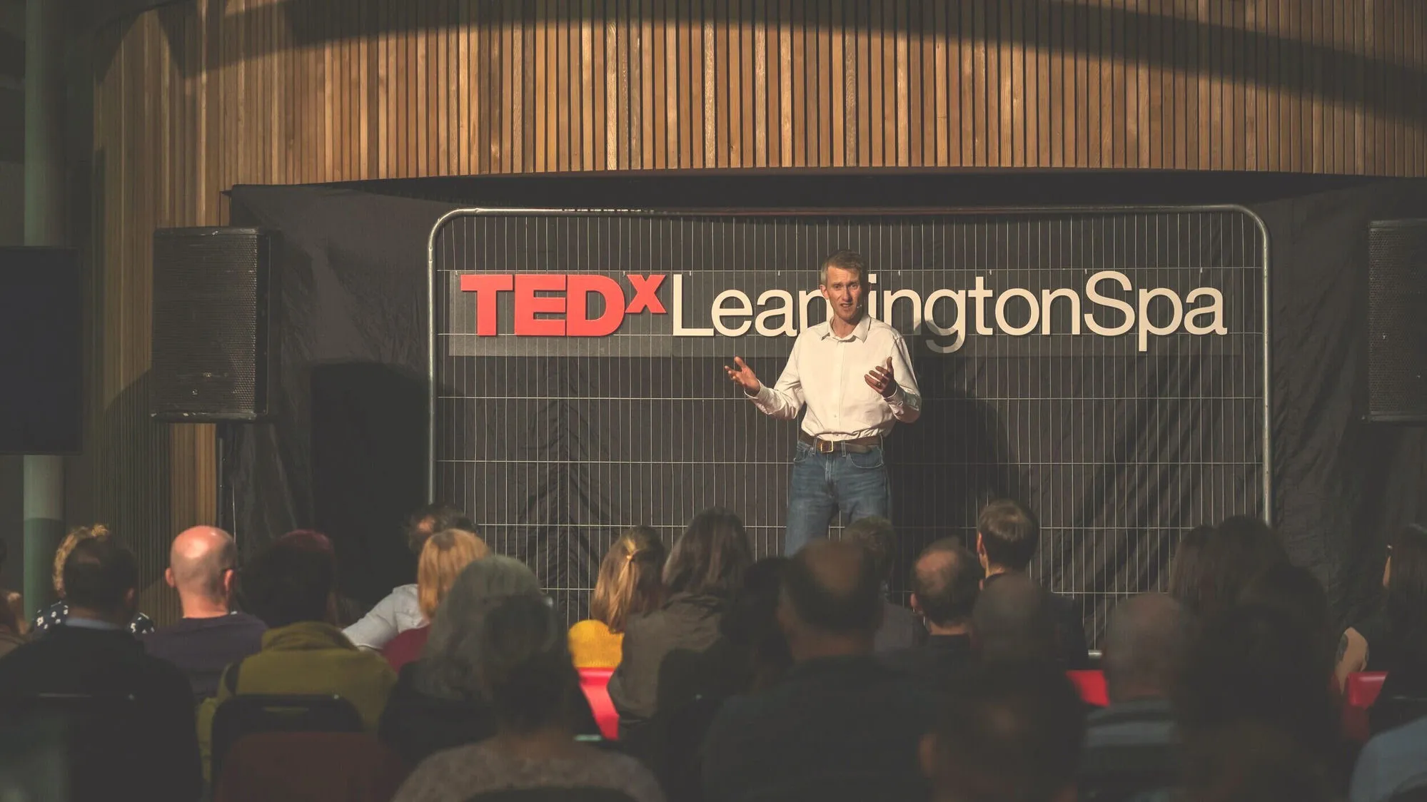 Andrew Pain delivering his TEDx talk to a seated audience